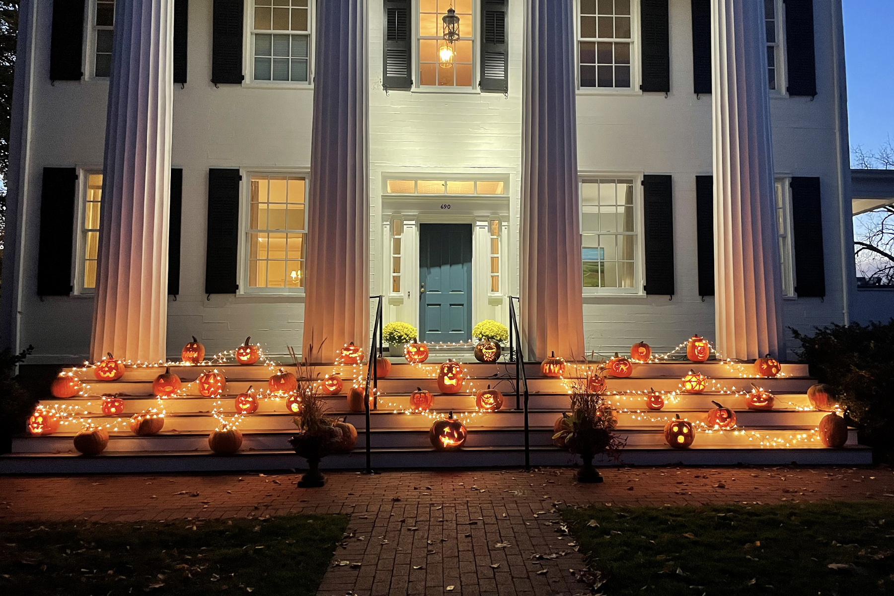 Pumpkins carved by students illuminate the President’s House on South Main Street following a Halloween open house hosted by President Mark D. Gearan and Mary Herlihy Gearan on Sunday.