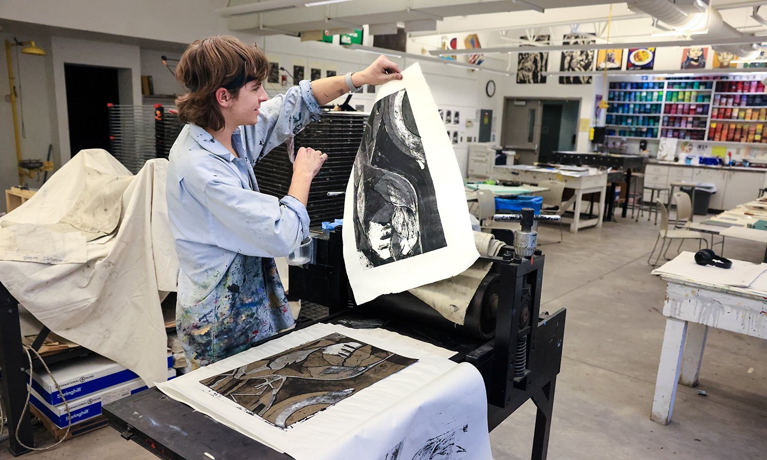 After running his print through the press, Jake Wright ’23 removes his design from the printing plate at the Katherine D. Elliott Studio Arts Center.
