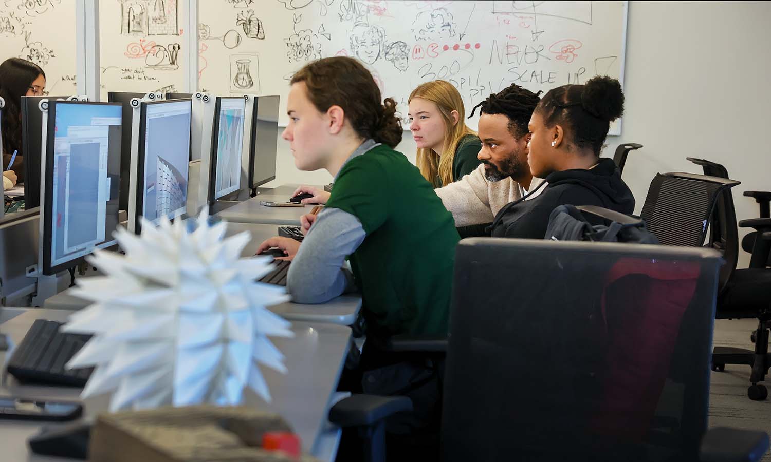 Assistant Professor of Art and Architecture Max Piersol works with students in “Intro to Digital Design” in the technology lab of the Katherine D. Elliott Studio Arts Center.