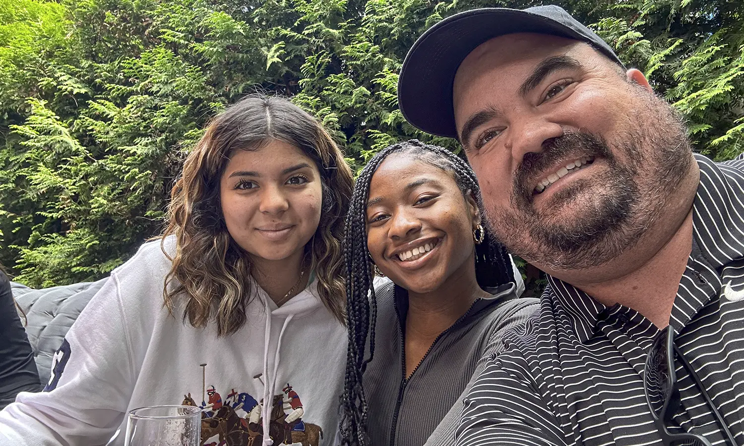 Juliza Ariza ‘27, Yashimabet Drummond ’24 and Associate Professor of Management and Entrepreneurship Craig Talmage take a selfie during their welcome lunch at Brauhaus Lemke.