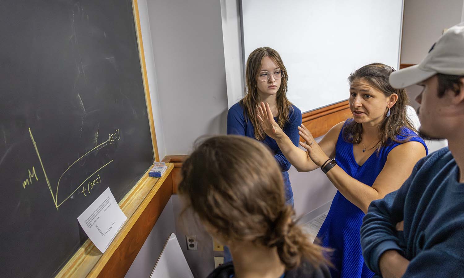 Professor of Chemistry Kristin Slade speaks to students working on a group assignment during “Biochemistry I.”