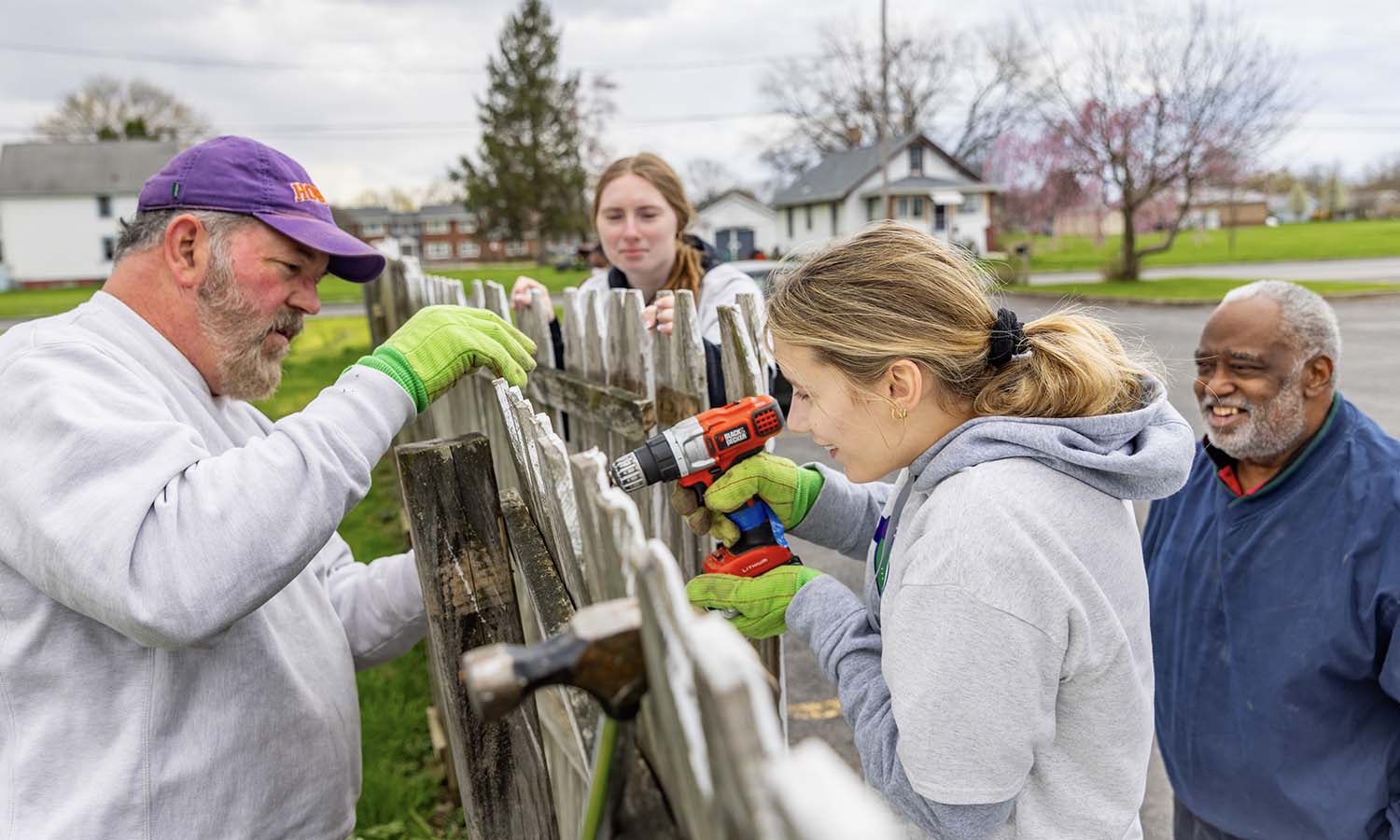 Students and community members repairing a fence