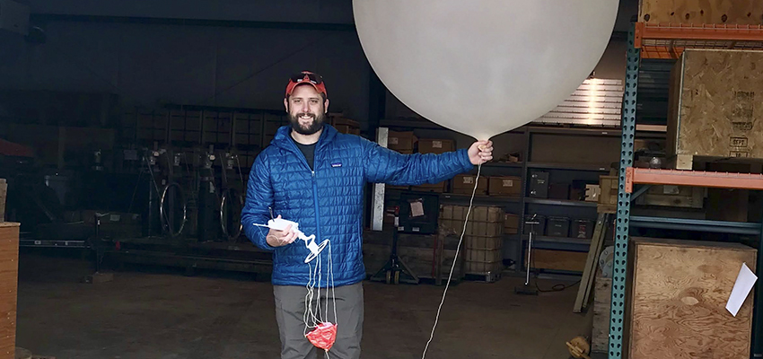 As a hydrometeorological research analyst Chad Hecht ’14 works with a weather balloon.